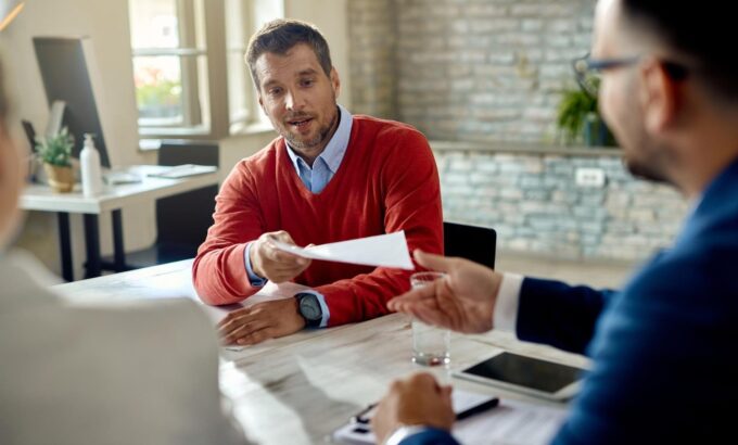 male-candidate-giving-his-cv-member-human-resource-team-while-having-job-interview-office